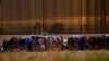 Migrantes cerca del muro fronterizo después de cruzar el río Bravo con la intención de entregarse a los agentes de la Patrulla Fronteriza de los Estados Unidos. (REUTERS: José Luis González).