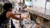Una mujer cuelga ropa en una tendedera cerca de un montón de basura en la calle, en La Habana, Cuba, 31 de agosto de 2024. REUTERS/Norlys Perez