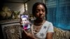Mayda Yudith Sotolongo sostiene una foto de su hijo, Yunir Consuegra, joven discapacitado detenido el 11J. (YAMIL LAGE / AFP)